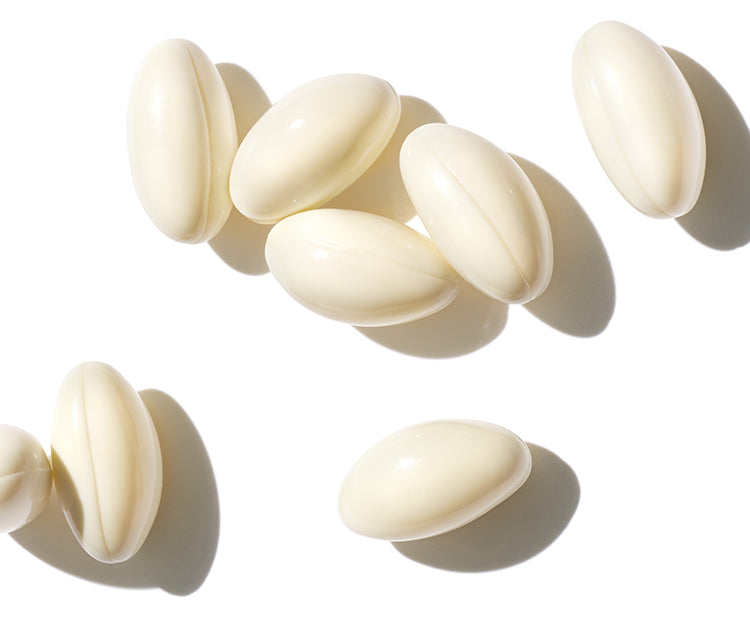 A group of cream colored capsules on a white background