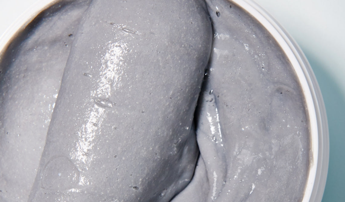 Grey, gritty texture shot of scalp revival exfoliating shampoo.